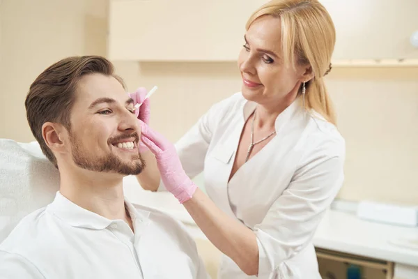 Agradável Macho Sorrindo Cadeira Dentro Clínica Medicina Estética Enquanto Feminino — Fotografia de Stock