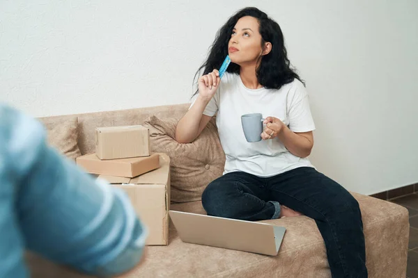 Pensieve Vrouw Zittend Bank Met Debetkaart Hand Omhoog Kijkend — Stockfoto