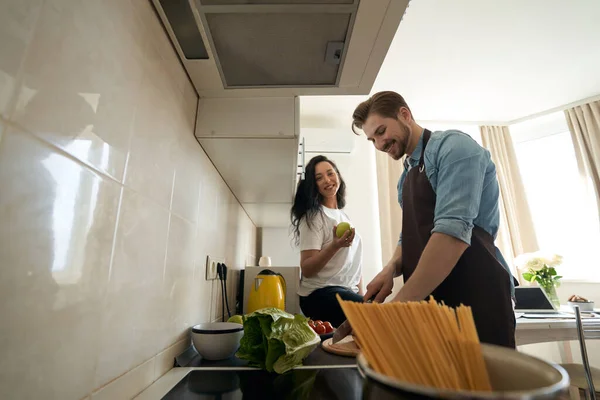 Жінка Сидить Кухонній Стійці Усміхаючись Молодий Чоловік Готує Вечерю — стокове фото