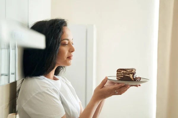 Женщина Смотрит Кусок Модного Торта Тарелке Руках — стоковое фото