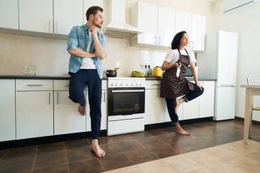 Elinde bıçakla hoşnutsuz bir kadın ve eşi birbirlerinden ayrı duruyorlar.