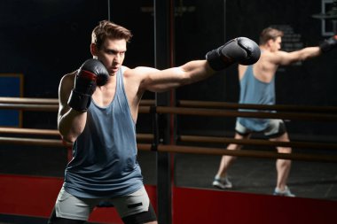 Sportsperson dövüş pozisyonunda duruyor ve sol elle düz bir yumruk atıyor.