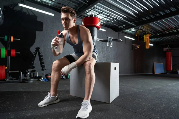 Atletisch Mannetje Met Fles Water Zittend Plyo Box Kijkend Naar — Stockfoto