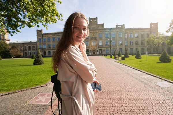 幸せな女性スタンド半分ターンオンザ歩道彼女の手タッチ彼女の首 — ストック写真