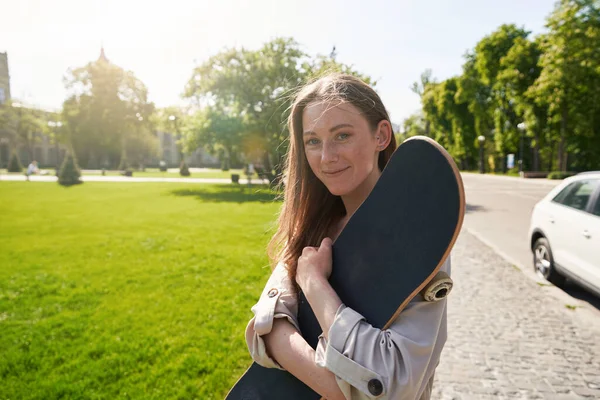Sorrindo Mulher Segurando Skate Enquanto Entre Calçada Parque — Fotografia de Stock