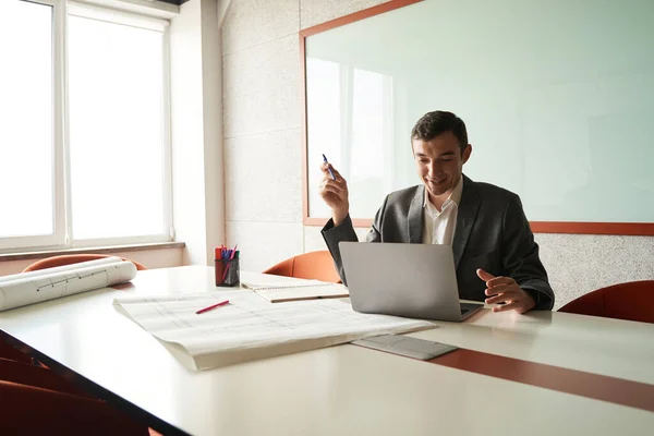 Mannelijke Kantoormedewerker Glimlachen Met Verlichting Terwijl Zitten Met Pen Hand — Stockfoto