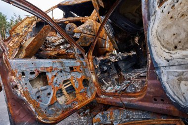 Ukrayna 'nın Ukrayna, Bucha bölgesindeki hurdalıkta şarapnel ve mermilerden hasar görmüş yanmış bir araba bulundu.