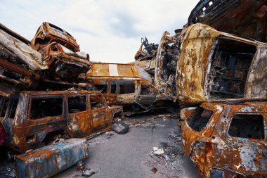 Urkaine 'deki Rus bombardımanı sonucu hurdalığa yığılan paslanmış ve tahrip edilmiş otomobiller