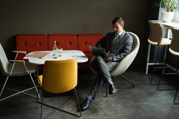 Hombre Negocios Sentado Cómodamente Silla Mesa Mientras Usa Ordenador Portátil —  Fotos de Stock