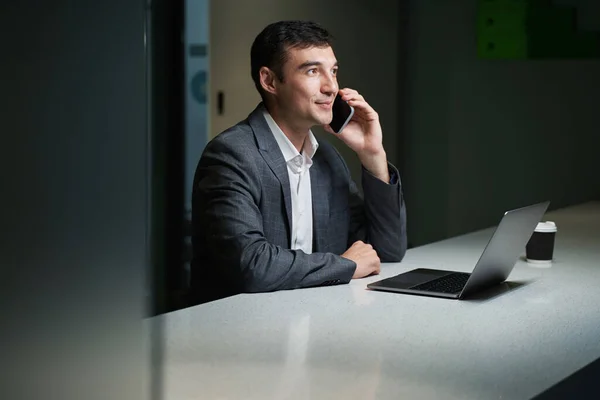 Pleased Caucasian Businessman Long Table Speaking Mobile Phone Laptop Him — Stockfoto