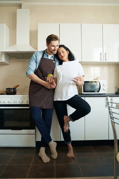 Улыбающиеся Мужчины Сконцентрированные Женщины Прислоняются Кухонной Стойке Просматривают Документы — стоковое фото