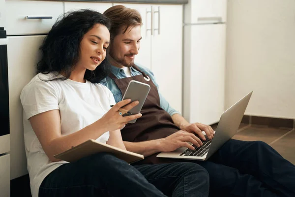 Mujer Con Teléfono Inteligente Sentado Suelo Lado Sonriente Hombre Contento — Foto de Stock