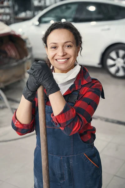 若い女性の整備士は幸せを感じながら完成車の塗り直し — ストック写真