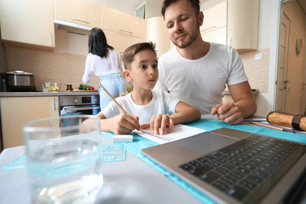 Helpful Father Peeking Kid Notes Notebook While Boy Doing Homework — Stock Photo, Image