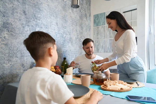 Junge Beobachtet Wie Seine Mutter Salat Auf Den Teller Des — Stockfoto