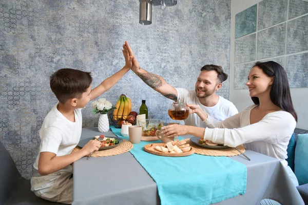 Kid Giving High Five Father Table While Mother Pouring Tea — Stockfoto
