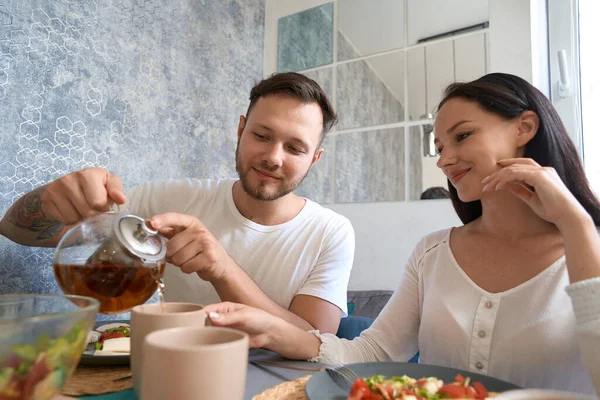 Kadın Yemek Boyunca Masada Otururken Kocasının Bardağını Çayla Doldurmasını Izliyor — Stok fotoğraf