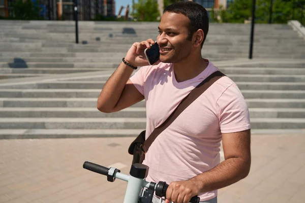 Waist Portrait Cheerful Guy Leaning Electric Scooter Handlebars Phone Conversation — Stockfoto