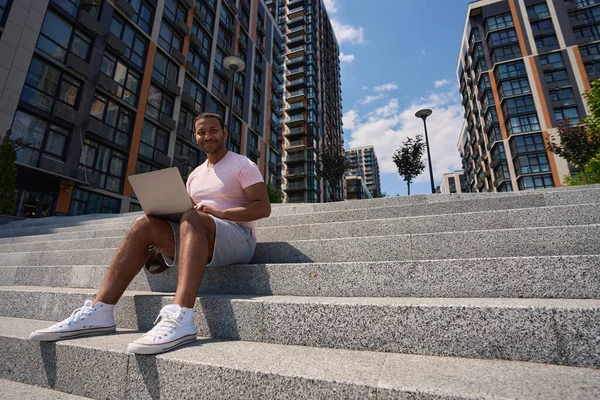 Leende Nöjd Ung Man Med Bärbar Dator Sitter Betong Trappor — Stockfoto