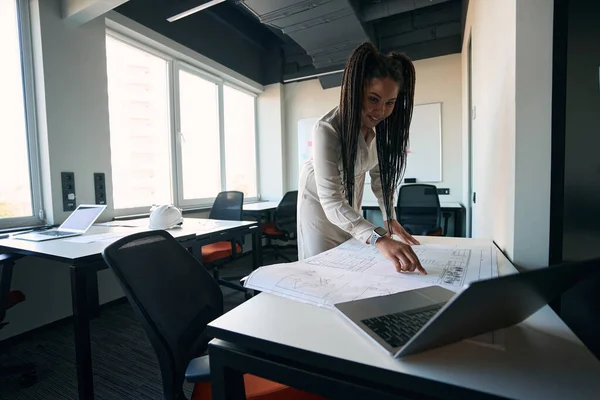 Focused Female Architect Leaning Rolled Out Technical Drawing While Looking — Stockfoto