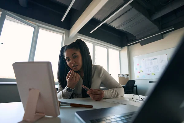 Calm Concentrated Female Office Worker Calling Smartphone While Applying Lip — Stock fotografie