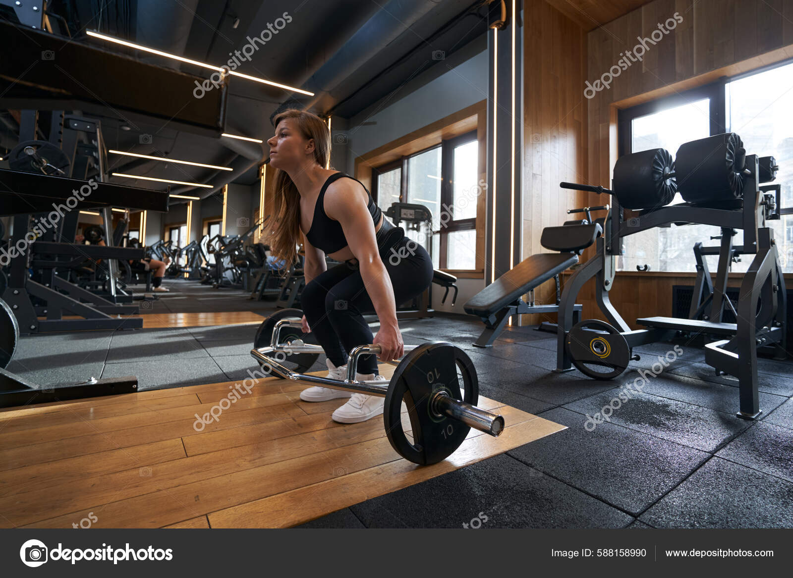 Strong Brawny Female Athlete Gripping Handles Plate Loaded Trap