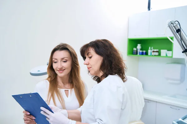 Doctor Pointing Smiling Female Patient Entry Medical Record — Photo