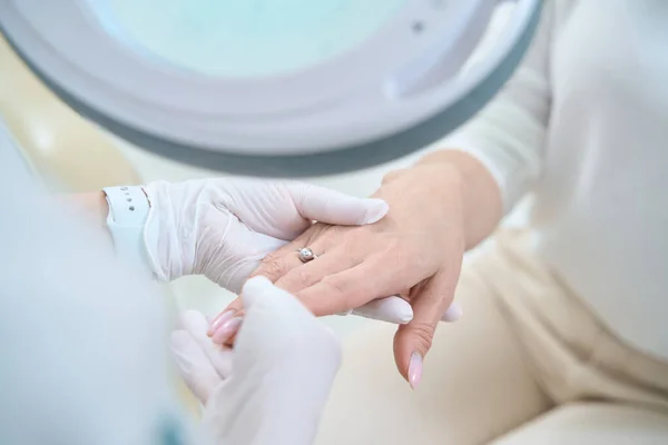 Mão Uma Mulher Caucasiana Com Anel Dedo Toca Mão Médico — Fotografia de Stock