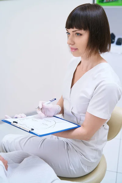 Attentive Cosmetologist Enters Data Patient Card — Stockfoto