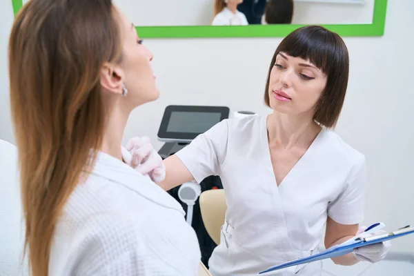 Cosmetologist Atencioso Examina Pele Paciente — Fotografia de Stock