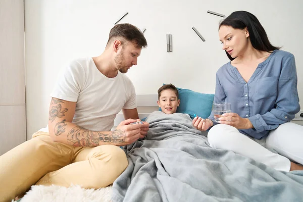 Caring Young Parents Fussing Bedside Sick Teenager Son Thermometer Pills — Fotografie, imagine de stoc