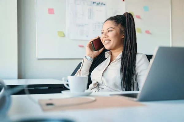 Smiling Female Entrepreneur Sitting Office Table Looking Distance Phone Conversation —  Fotos de Stock
