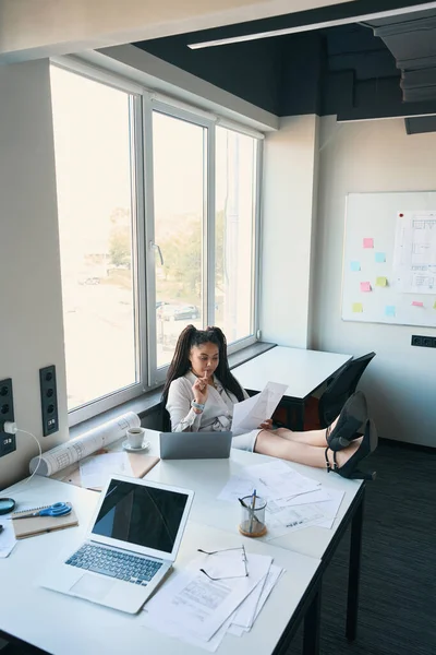 Serious Female Architect Seated Office Staring Documents Her Hands — 스톡 사진