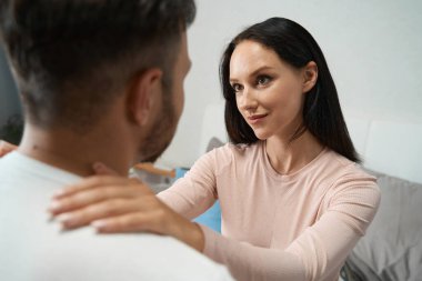 Genç çiftin romantik şefkatli kucaklaşmaları, kadının ellerini erkeğin omuzlarına koyup gözlerinin içine bakması.