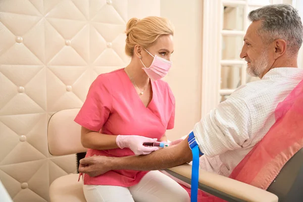 Beautiful Female Doctor Draws Blood Male Patient Syringe Looks Away — Stock fotografie