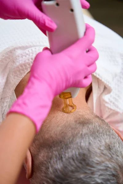 Laser hair removal on the back of the head close-up. Man lying face down in a chair