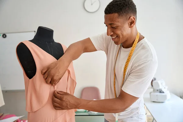 Jolly African American Male Tailor Tape Measurer Fixing Textile Mannequin — стоковое фото