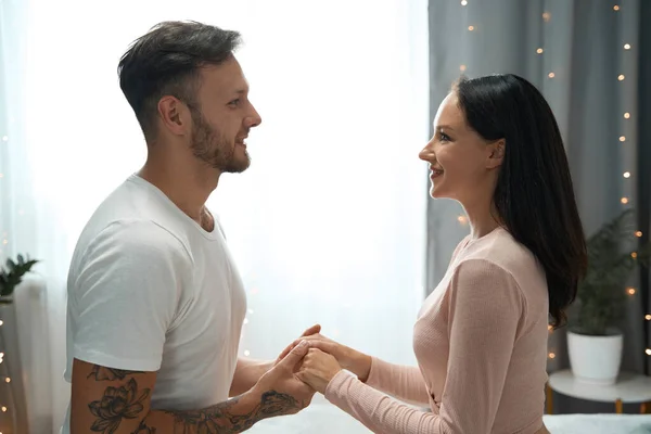 Romantic Moment Room Decorated Garlands Smiling Beautiful Couple Holding Hands — Stockfoto