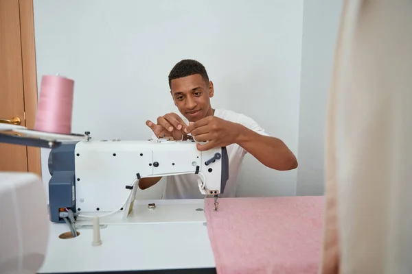 Счастливый Афроамериканец Использует Швейную Машинку Создания Одежды Розовой Ткани Мастерской — стоковое фото