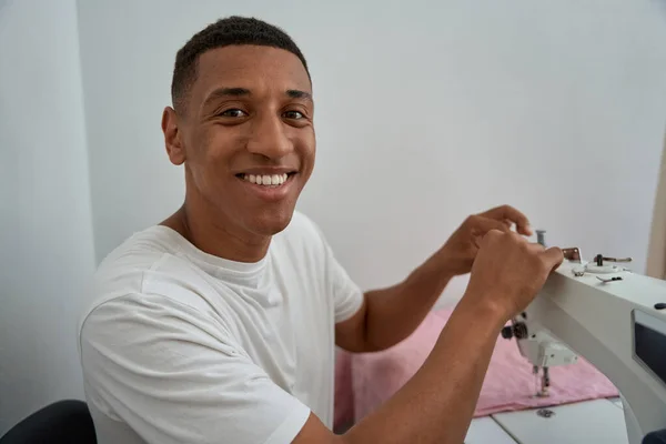 Portrait Smiling African American Male Tailor Sitting Table Using Equipment – stockfoto