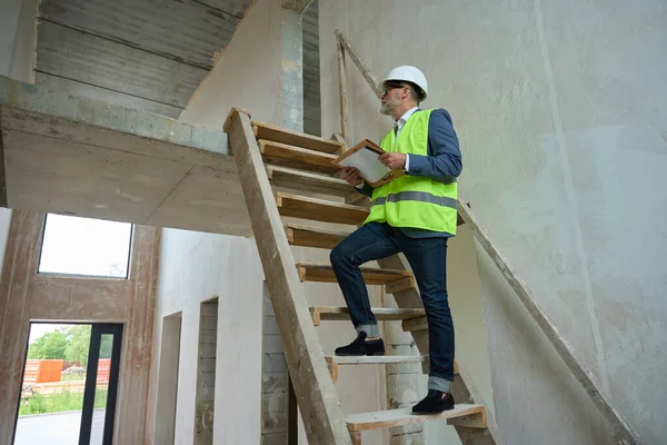 Male Foreman Protective Helmet Green Construction Vest Climbs Wooden Ladder — ストック写真