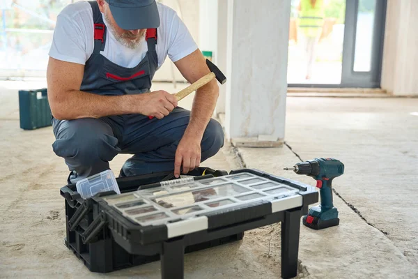 Bearded Builder Overalls Hammer His Hand Looking Toolbox Man Unfinished — Stockfoto