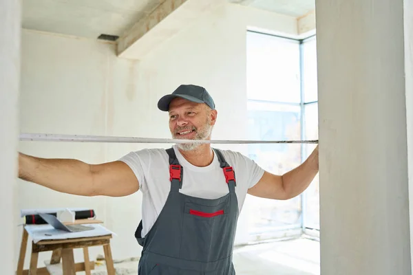 Smiling Gray Haired Worker Measures Width Doorway Tape Measure Photo — ストック写真