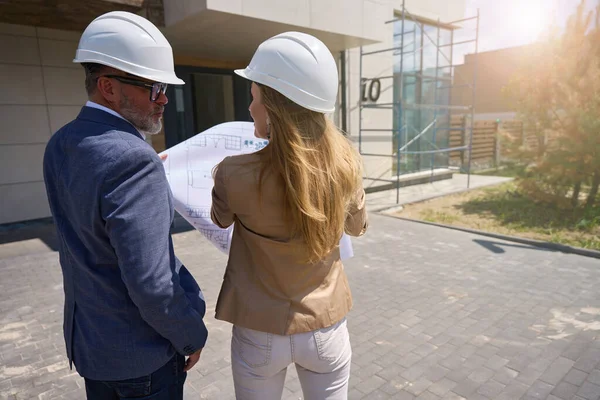 Male Client Female Realtor Protective Helmets Look Drawing Cottage Back — Stock fotografie