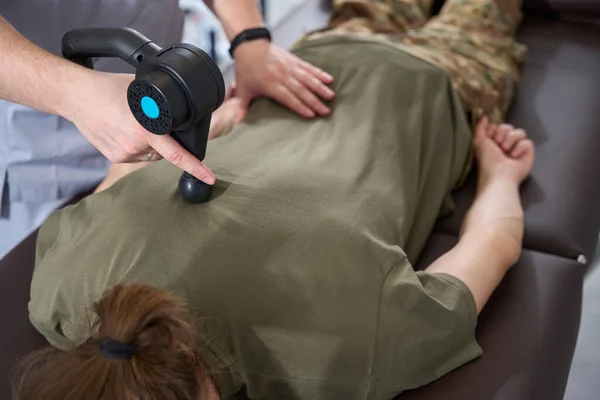 Hardware rehabilitation treatment in a rehabilitation center, a fighter lies on a couch, a doctor works with his back