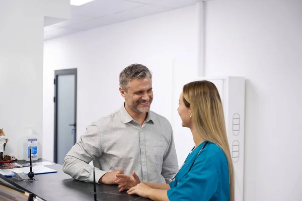Man Communicates Doctor Dressed Blue Uniform Corridor Hospital — Stockfoto