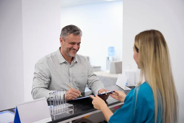 Caucasian Guy Smiling Signing Documents Lobby Hospital — Stock Photo, Image