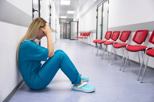 Doctor Sits Floor Corridor Holding His Head — Zdjęcie stockowe