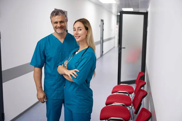 Doctors Look Camera While Standing Hospital Bright Corridor — Stock fotografie