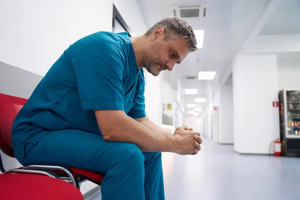 Adult Doctor Thinks Something While Sitting Corridor —  Fotos de Stock